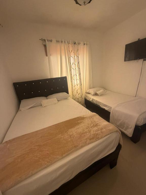 a bedroom with two beds and a window at Hostal mar de luna in Pedernales