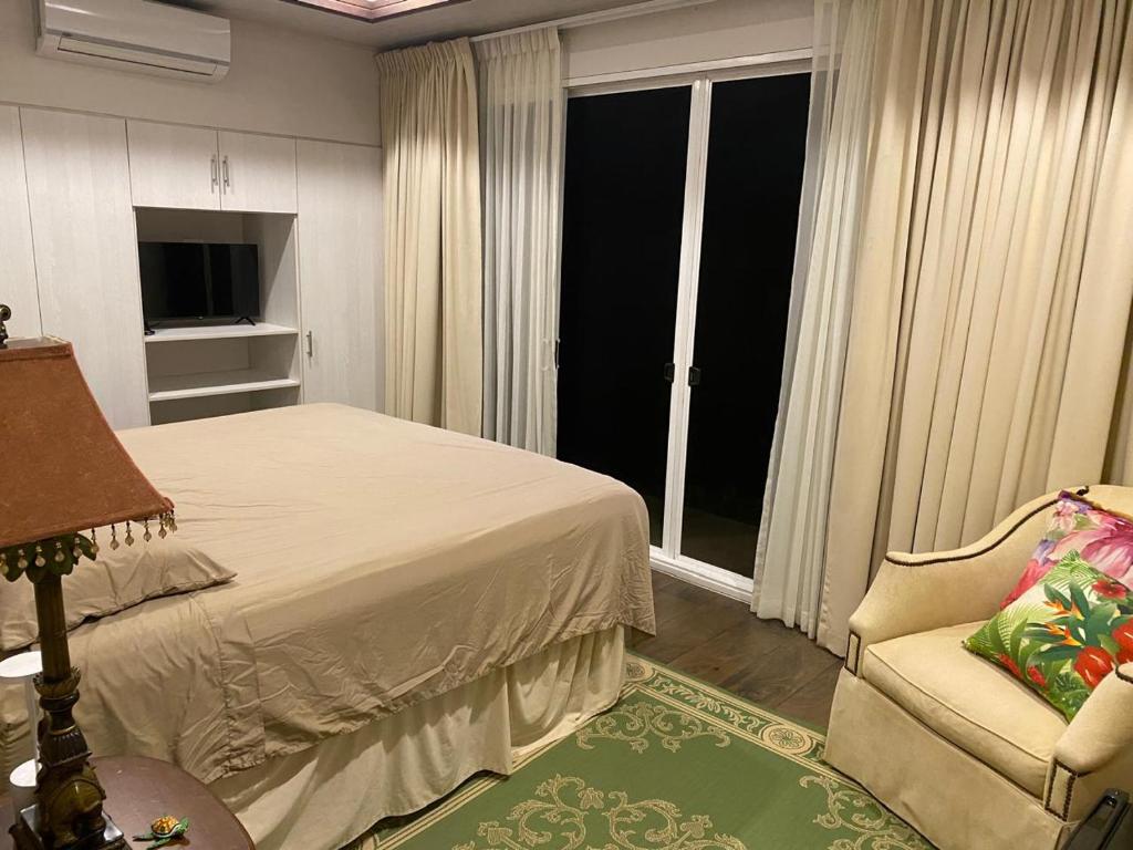 a bedroom with a bed and a chair and a window at Apartamento Dulces Sueños in Bahia