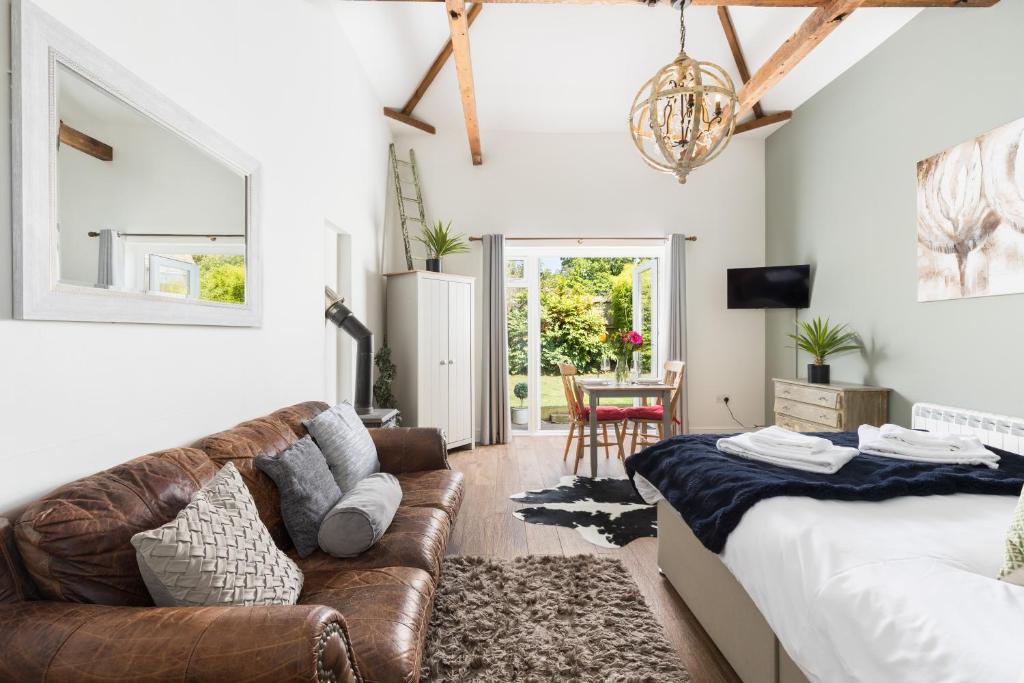 a living room with a couch and a table at Beautiful Cotswold Couples Retreat in Bourton on the Water