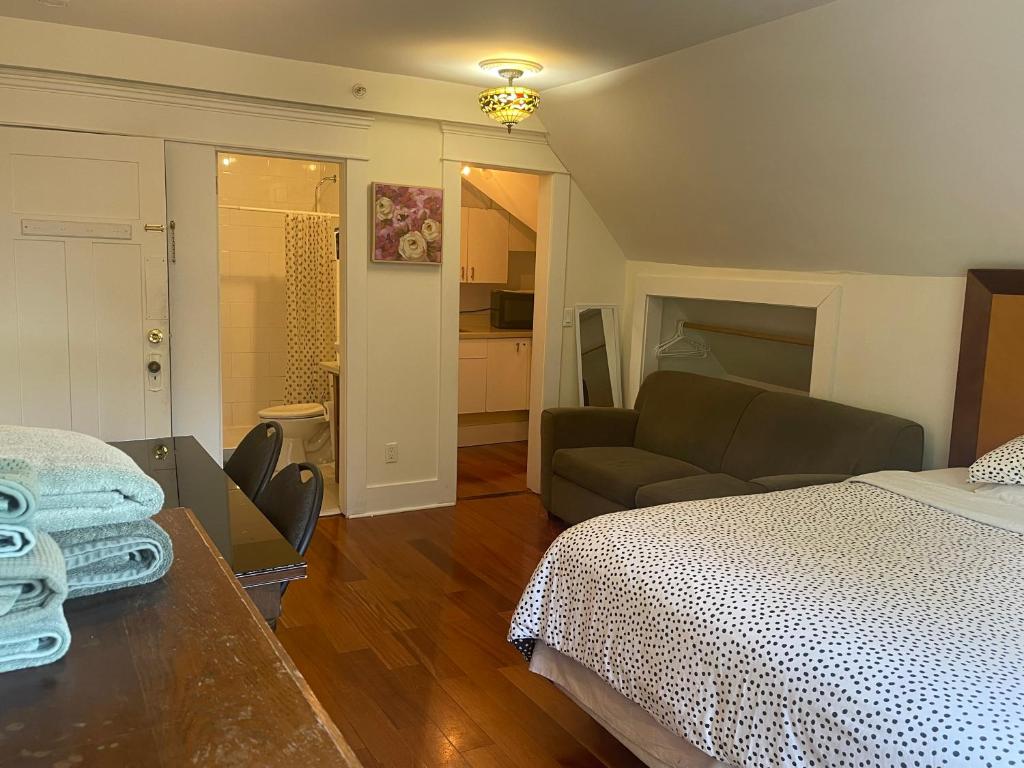 a bedroom with a bed and a living room with a couch at Cambie Guestshouse in Vancouver