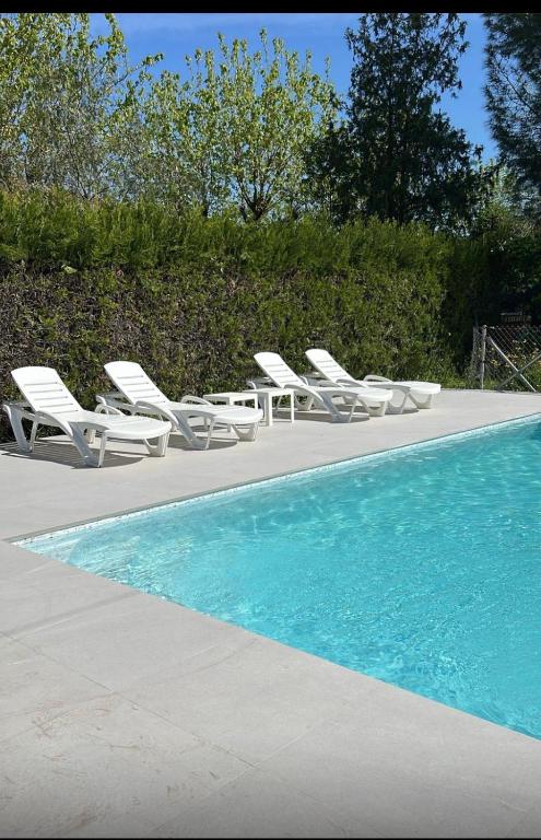 a group of lounge chairs and a swimming pool at Chalet con piscina en Carmona in Carmona