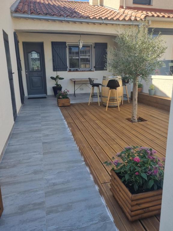 a wooden deck with a table on a house at Villa cocooning in Palavas-les-Flots