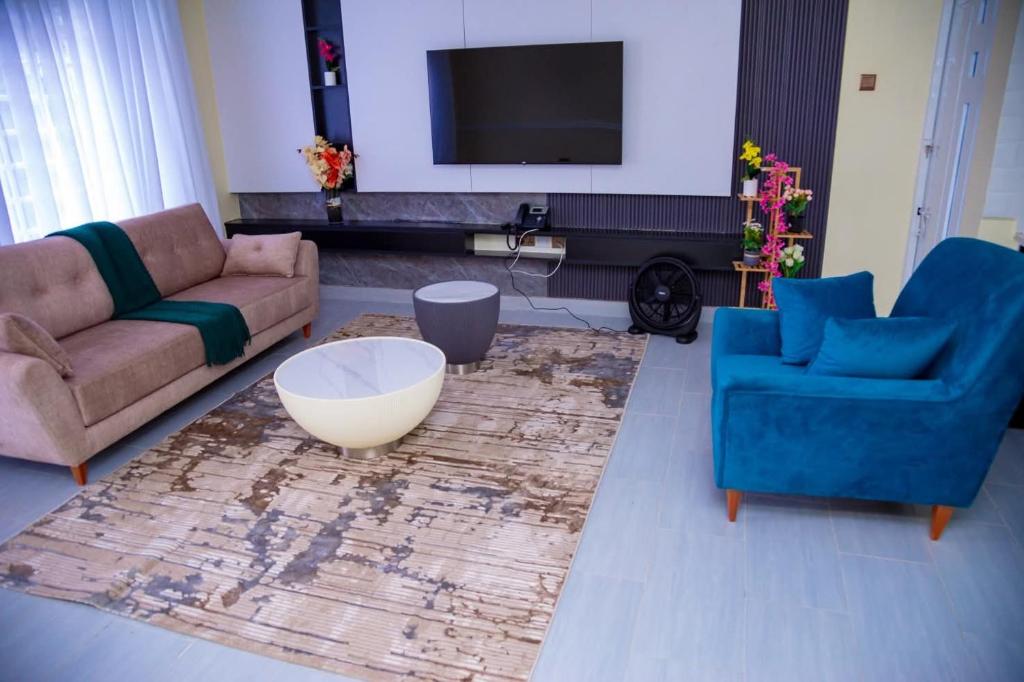 a living room with two couches and a tv at The VIP Afriqhomes in Nairobi