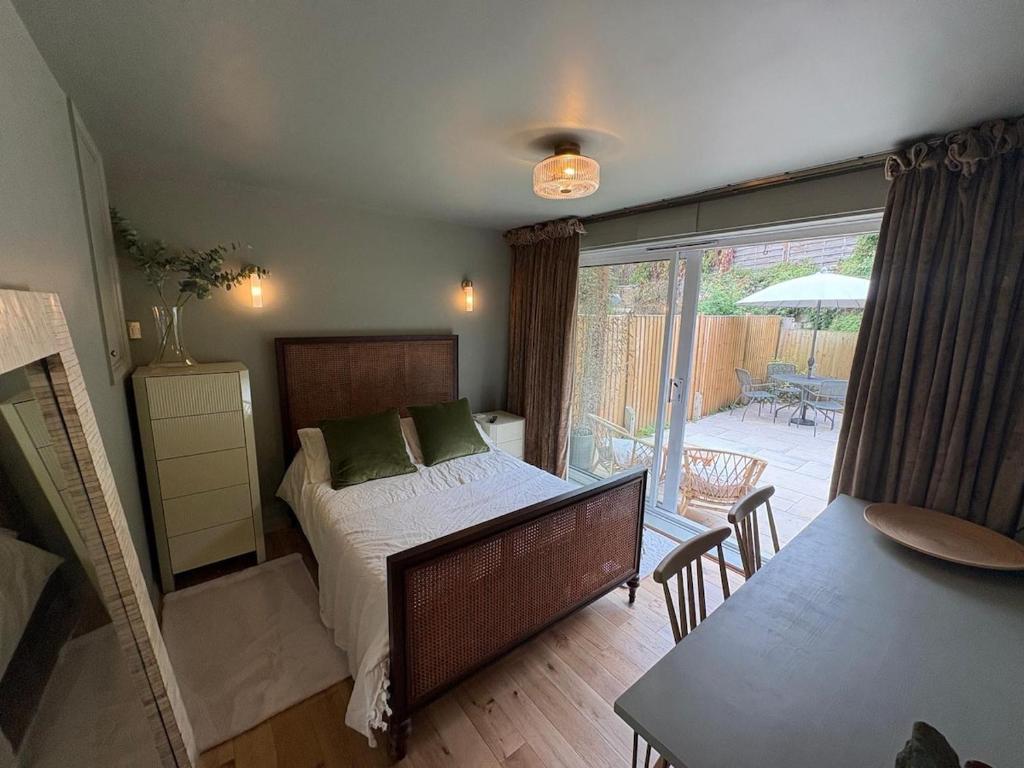 a bedroom with a bed and a table and a patio at The Warwick Room in Warwick