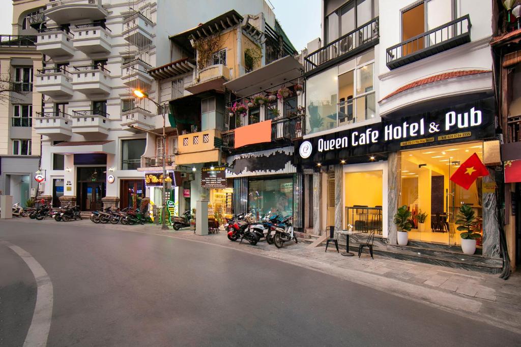 a city street with motorcycles parked in front of buildings at Queen Cafe Hostel in Hanoi