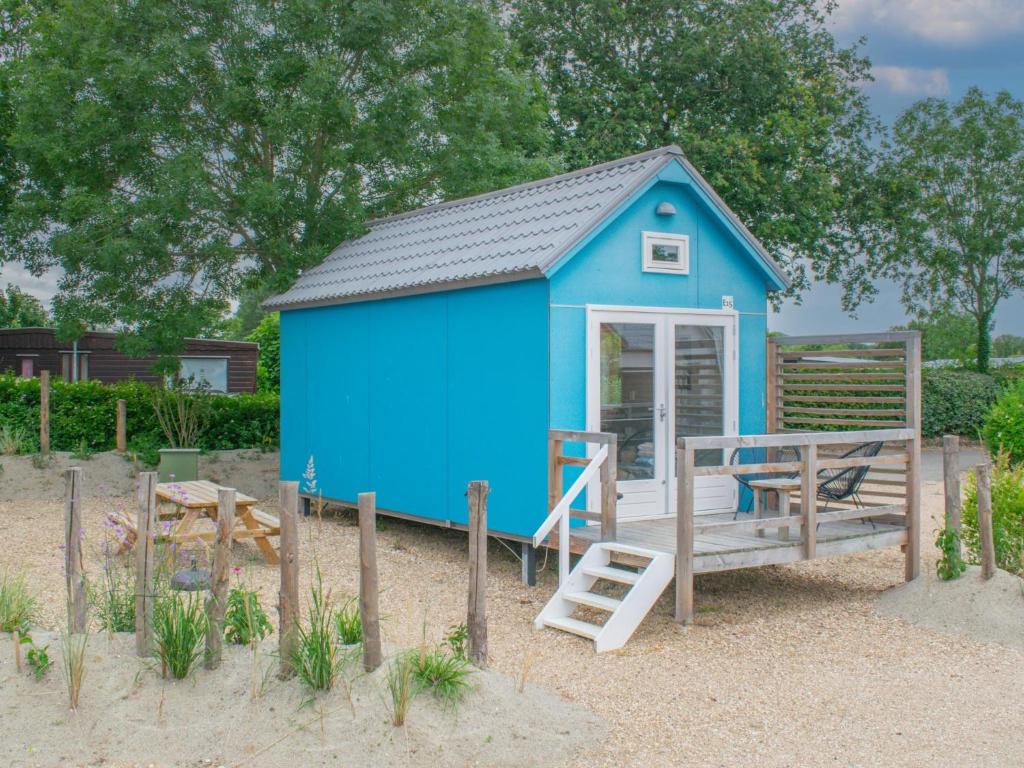 a blue shed with a staircase and a table at Bleu Dream in Ellemeet