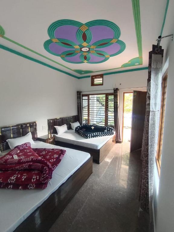 a bedroom with two beds and a ceiling with a flower on it at My Chopta Resort in Sari