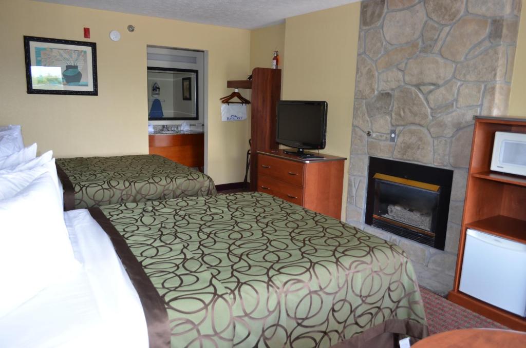 a hotel room with two beds and a fireplace at Baymont by Wyndham Pigeon Forge near Island Drive in Pigeon Forge