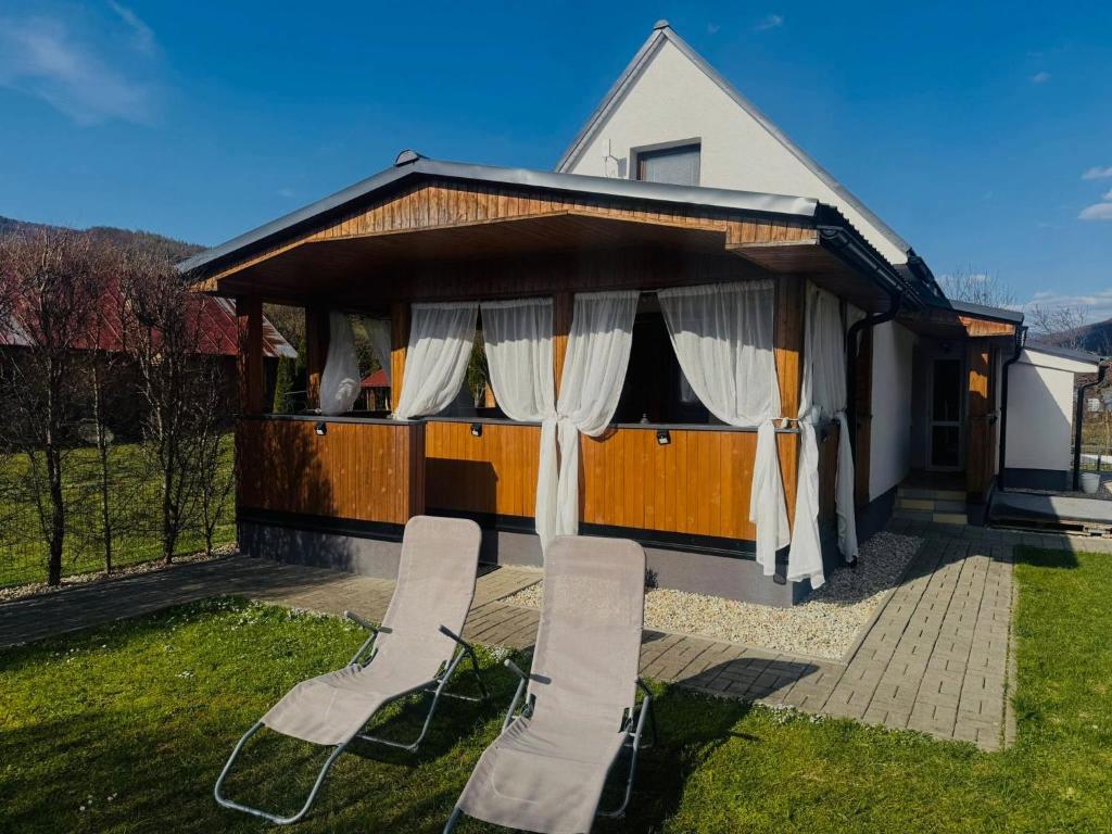 a house with two chairs in front of it at Chalúpka pod hviezdami in Uličské Krivé
