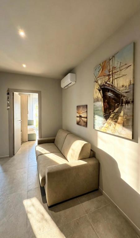 a living room with a couch and a painting on the wall at Casa Nanà - Sottomarina in Chioggia