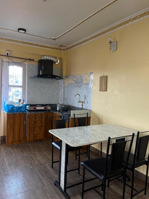 a kitchen with a table and chairs in a room at Lakecity Apartment in Pokhara