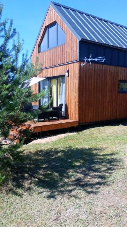 a wooden house with a large window in a yard at Domek letniskowy Płaska in Płaska