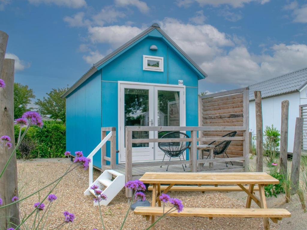 a blue shed with a picnic table and a bench at Seaside Blue in Ellemeet