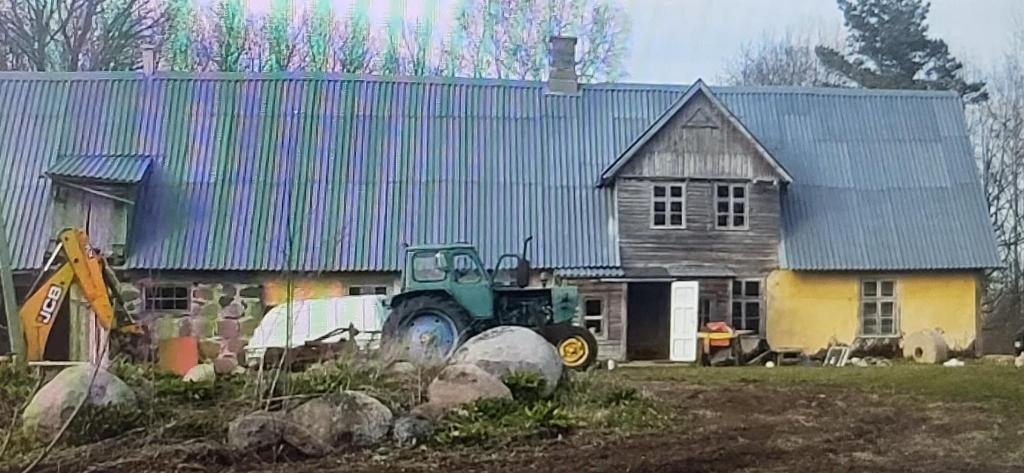 a green tractor parked in front of a house at Reedi talu in Rädi