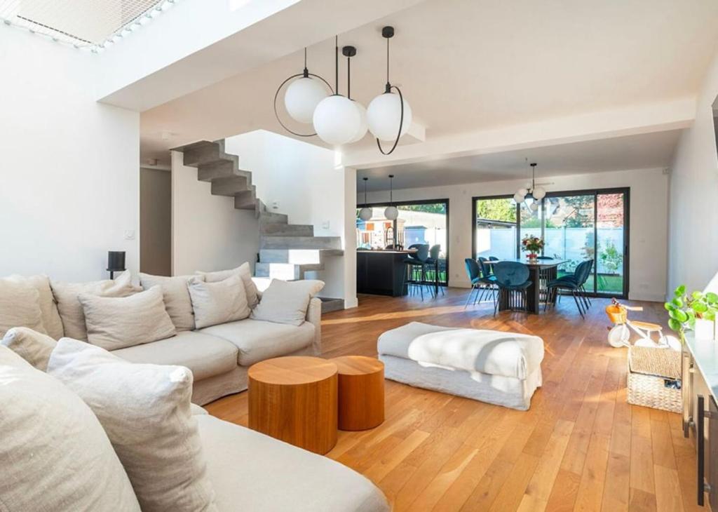 a living room with a couch and a table at House Moringa Rituals Pool in Le Plessis-Trévise