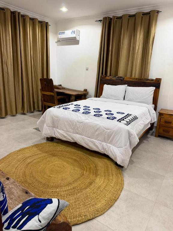 a bedroom with a large bed and a rug at 2BR Apartment in Tanga in Tanga