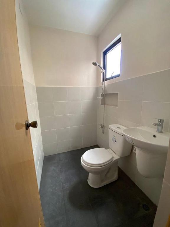 a bathroom with a toilet and a sink at maica's apartment in Taytay