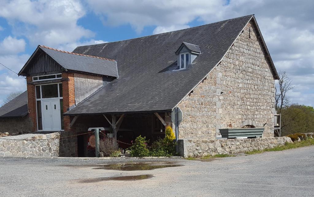 a large brick building with a bench in front of it at La Grange des Lavandes in Mérinchal