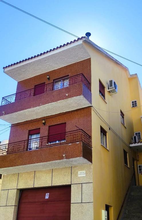 a tall brick building with a garage at Grandma Luísa's Corner in Verdelhos