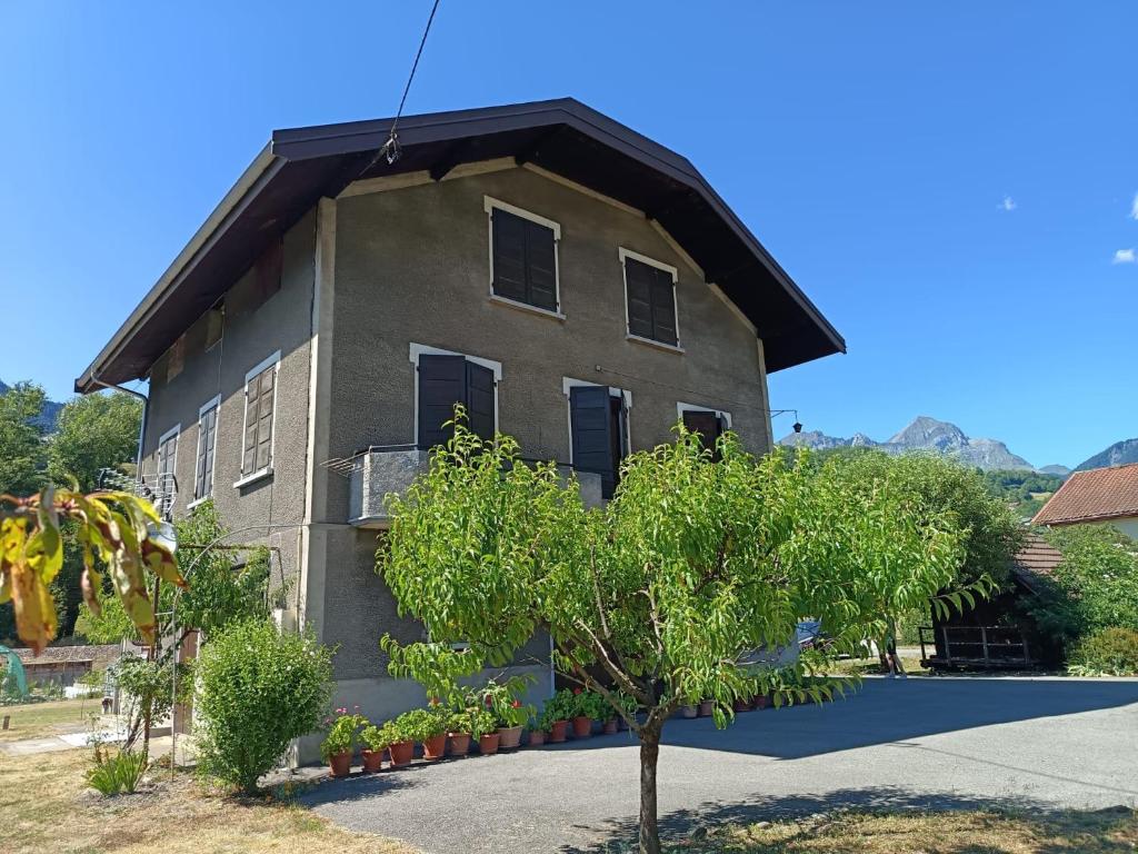 a house with a gambrel roof and a tree at Appartement Marthod in Marthod