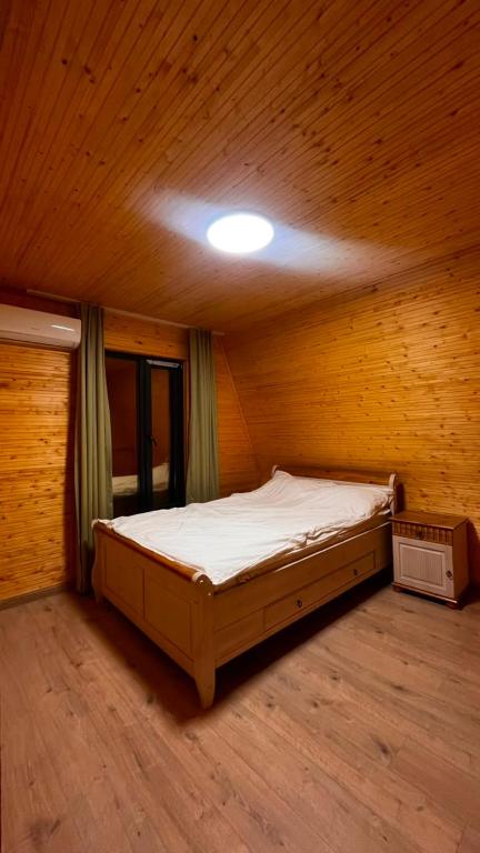 a bedroom with a bed in a wooden room at Kolsai Satu in Saty