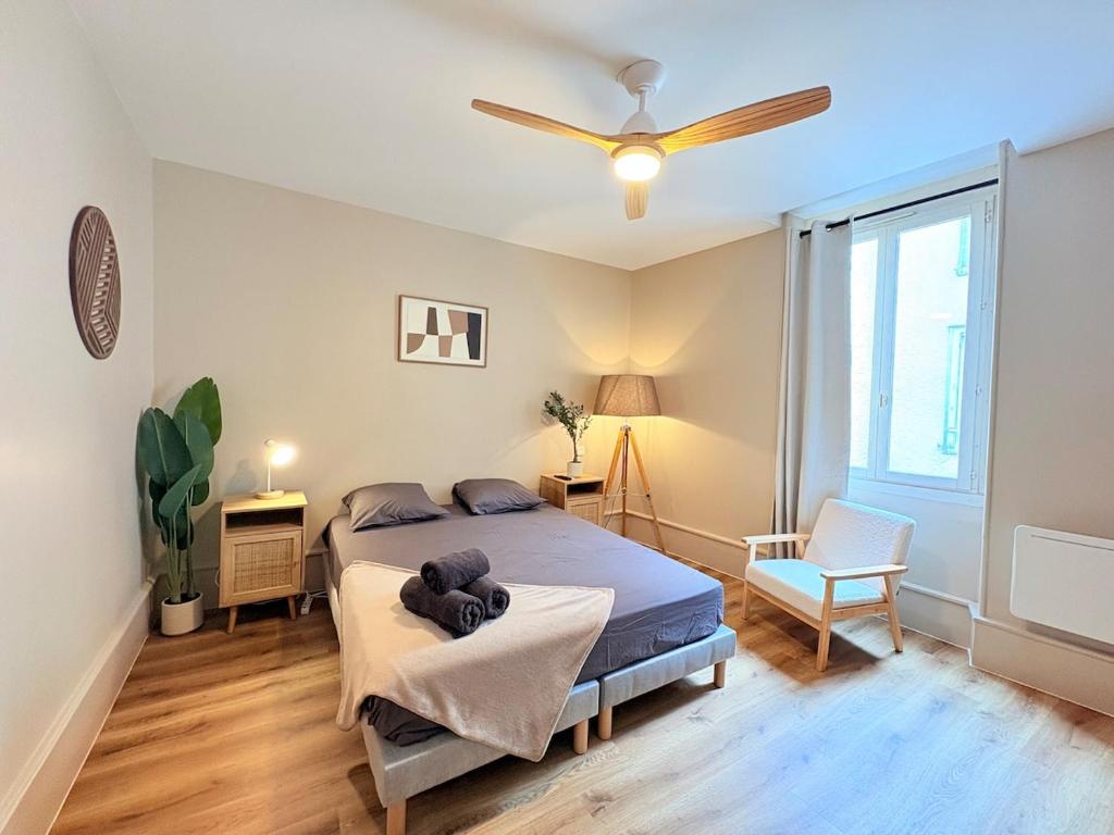 a bedroom with a bed and a ceiling fan at L'instant à Foix - Authentique & Chaleureux in Foix