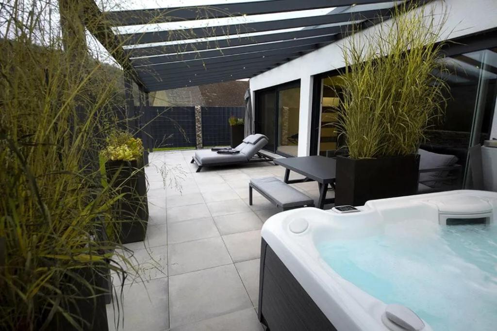 a patio with a hot tub and a table and chairs at Bellalaens in Zemst
