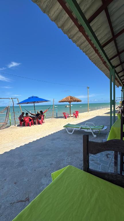 a beach with chairs and umbrellas and the ocean at Cantinho Muriu in Ceará-Mirim