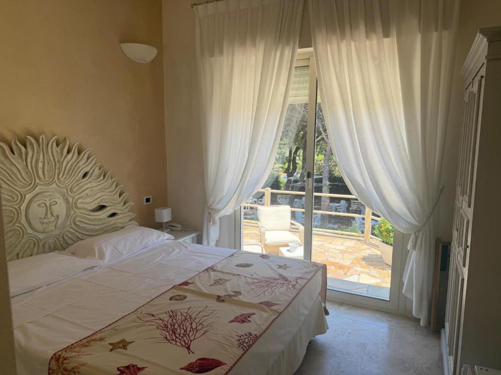 a bedroom with a bed and a door to a patio at Hotel Bagni Lido in Vada
