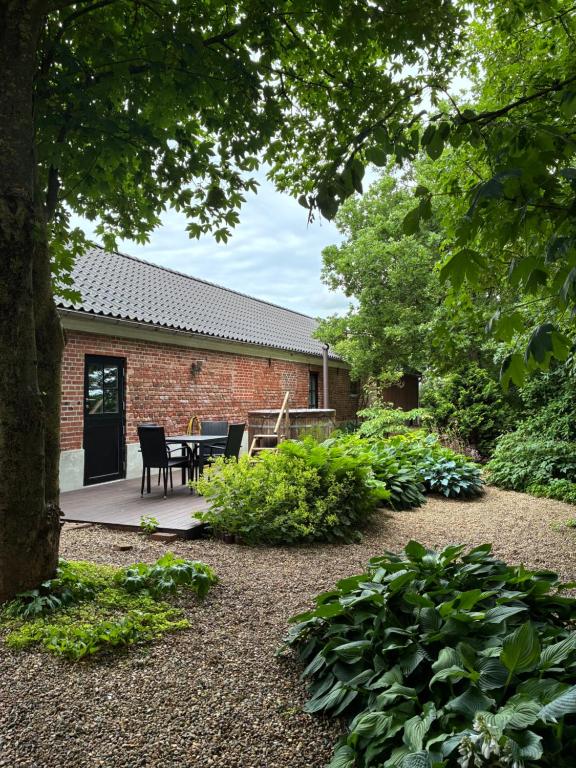 a garden with a table and chairs in front of a building at Gæstehuset in Tarm