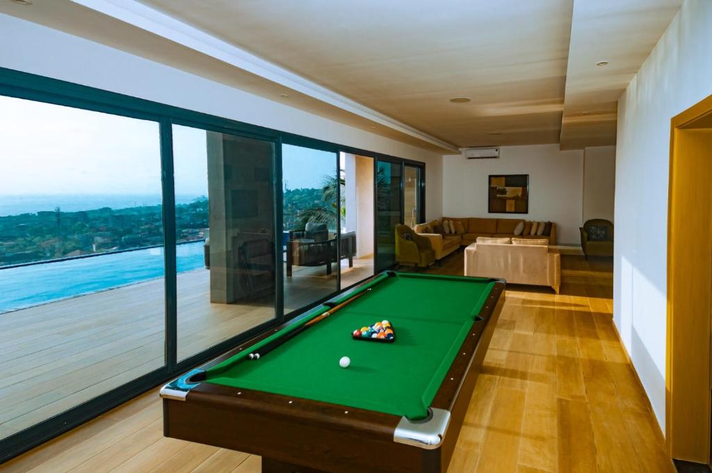 a pool table in a room with a view at Elegant Hillside Ocean Stay in Freetown