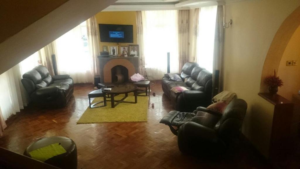 a living room with couches and a fire place at Mutabari's Home in Kitengela 
