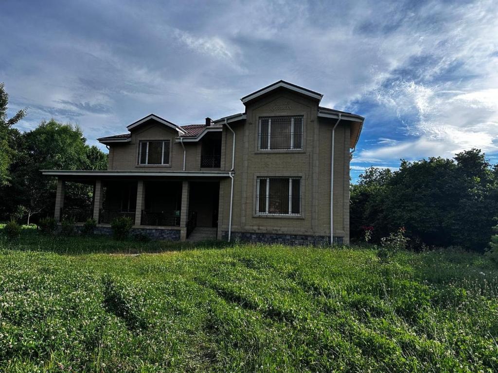 an old house on a grassy field in front thereof at House in Katex