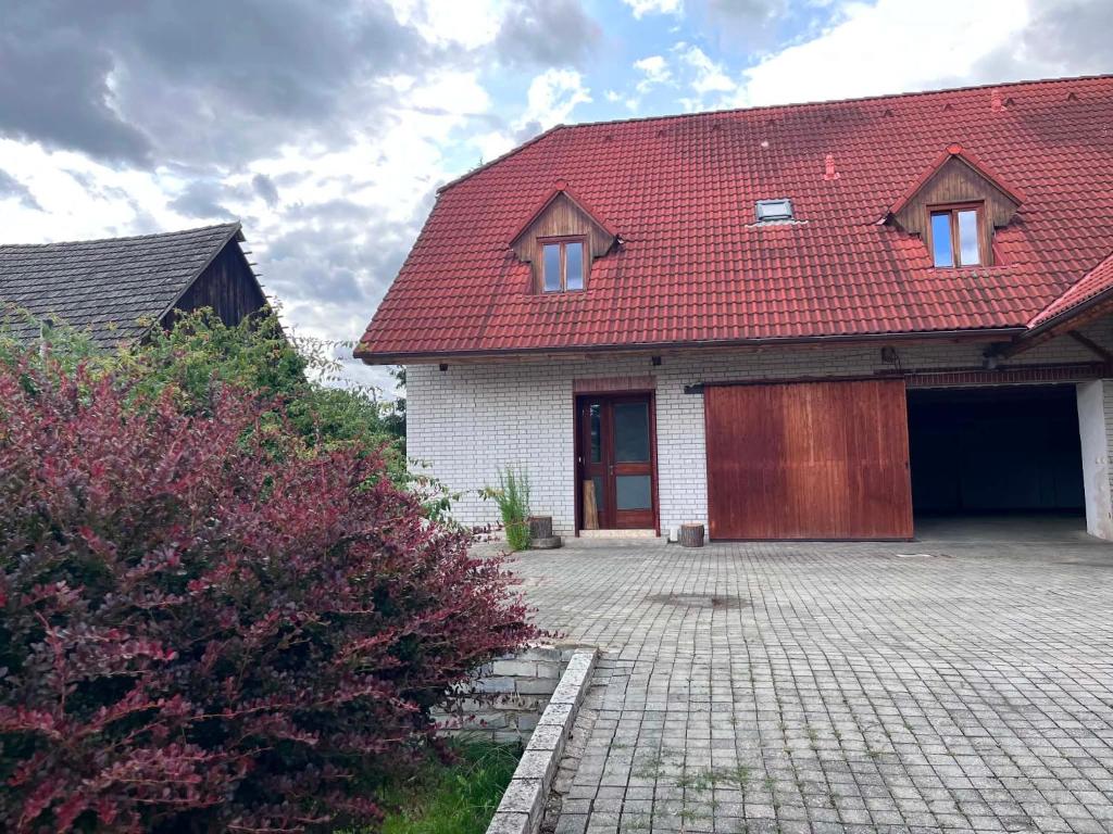 a house with a red roof and a driveway at Penzion Skřítkův grunt in Struhařov
