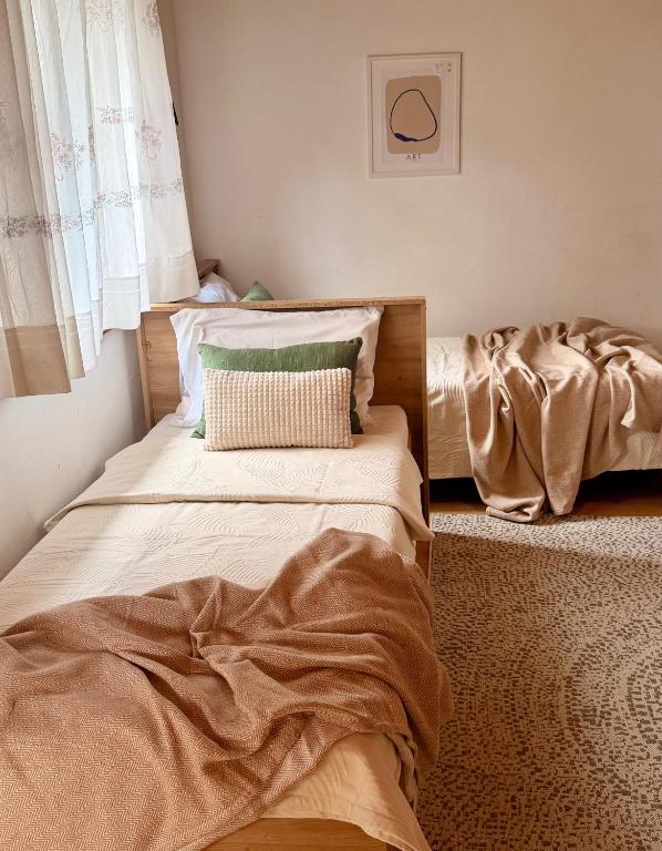 a bedroom with two beds and a window at Apartmani Selce za 2-3 osobe in Selce