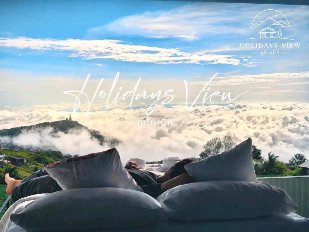 a person laying on a couch in the clouds at Holiday view ภูทับเบิก in Ban Maeo Thap Boek
