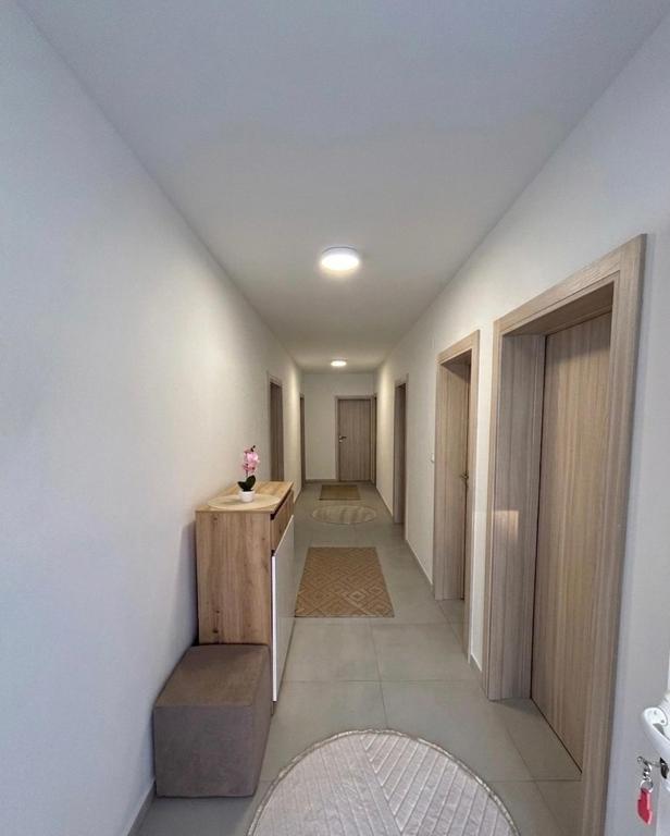 a hallway of a house with white walls and a room with a table at Apartman Šarenac in Bileća
