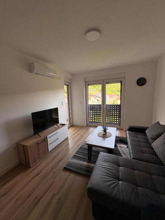 ein Wohnzimmer mit Sofa und Flachbildfernseher in der Unterkunft Apartment EDA in Bosanska Krupa
