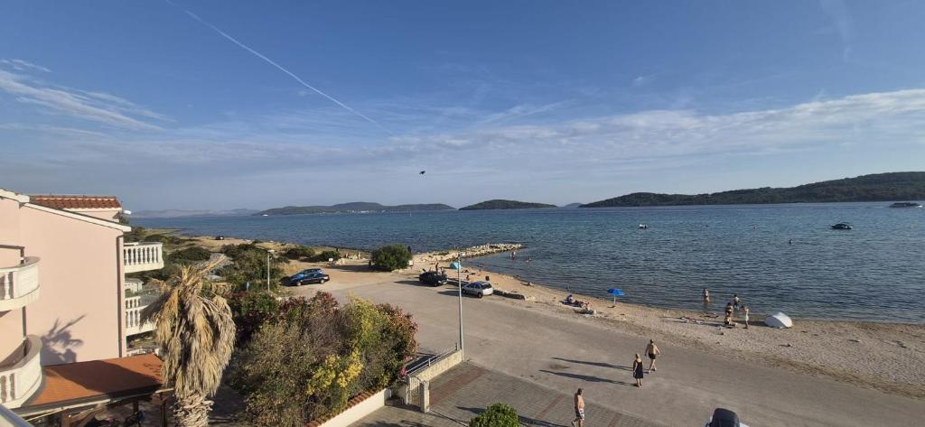 a beach with a kite flying over the water at ERE Apartment in Srima