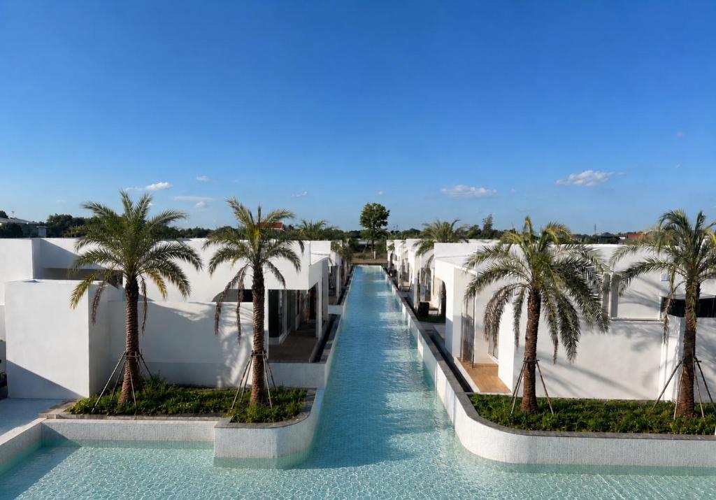 a waterway with palm trees on the side of a building at Anantita Poolside Boutique in Phra Nakhon Si Ayutthaya