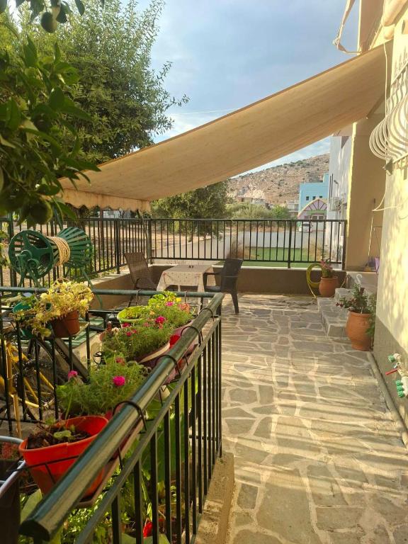 a patio with potted plants and awning on a balcony at Chrisa's Home in Salamina