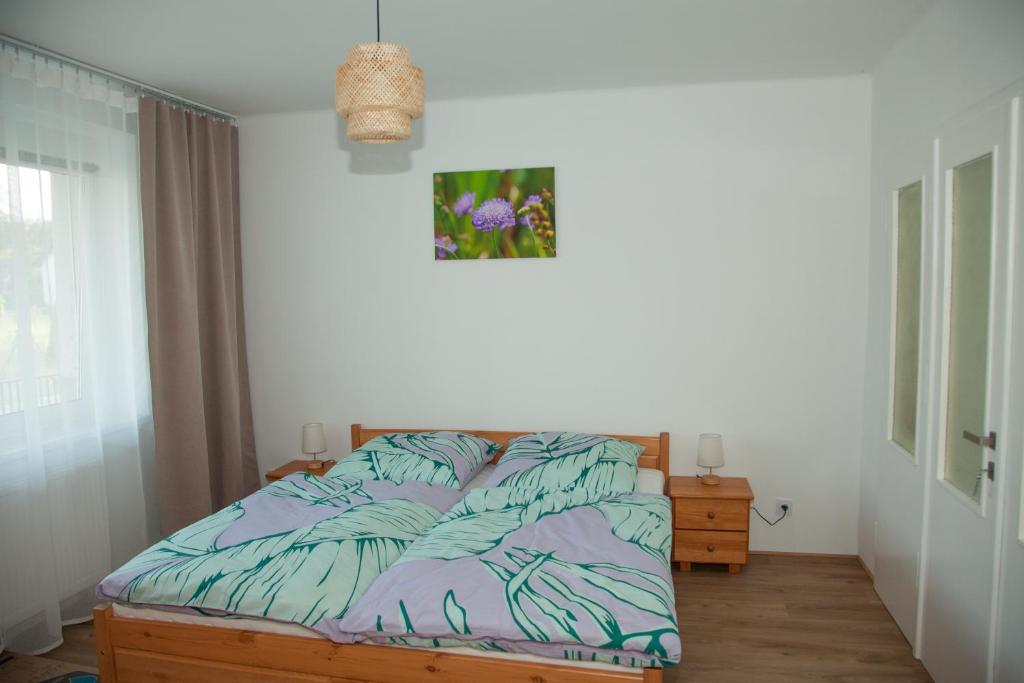 a bedroom with a bed with a comforter at Apartament Joanna in Szczedrzyk