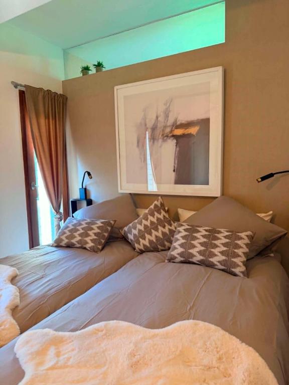 a bedroom with two beds and a picture on the wall at Au delà du miroir in Stavelot