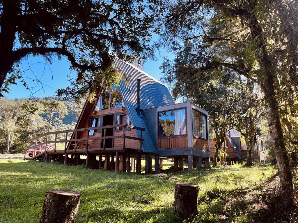 a tree house with a blue roof in the grass at Refúgio Bocaina in Bocaina do Sul