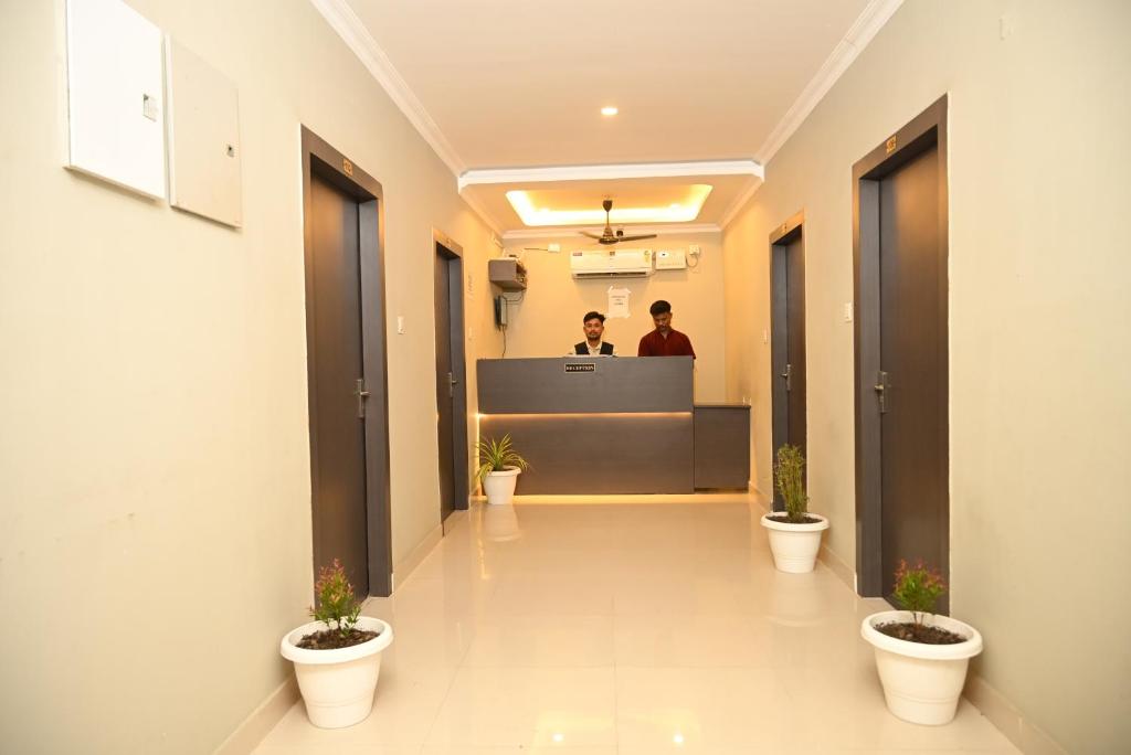 a lobby with two men standing at a reception desk at Hotel Vilasa Grand in Guwahati