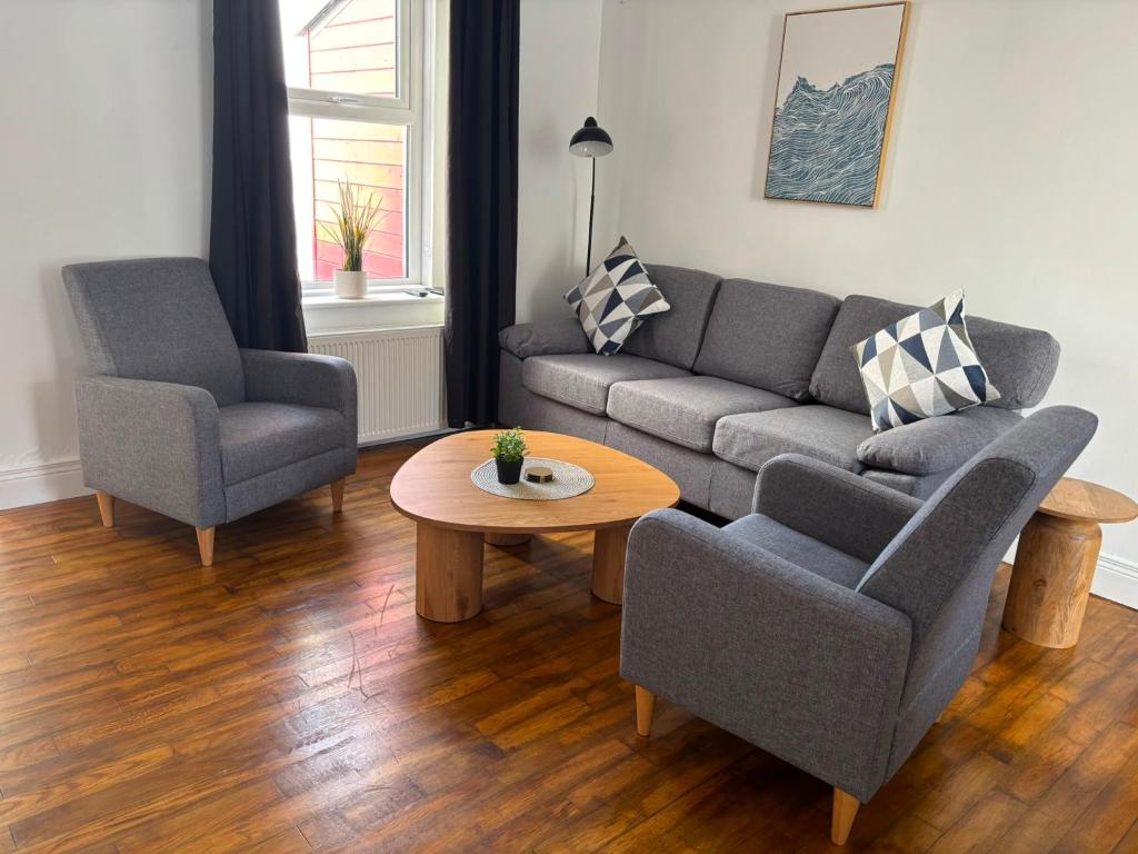 a living room with a couch and two chairs and a table at The Millstone in Buncrana