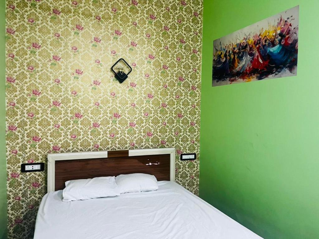 a bedroom with a bed and a green wall at Aman Convention in Chāndbāli