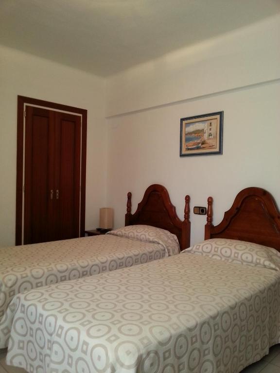 a bedroom with two beds and a door at Hotel Beri - Can Llançà in Llança