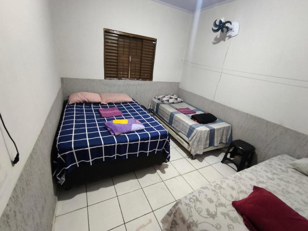 a bedroom with two beds and a window at Recanto do trabalho in Brasília