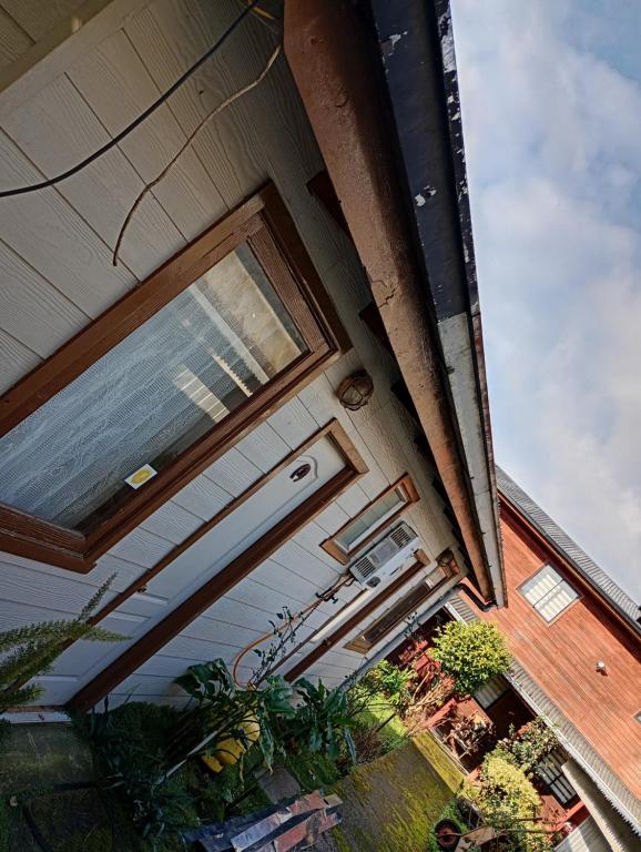 a sliding glass door on a house with plants at Hostal y Cabañas Guaje in Valdivia